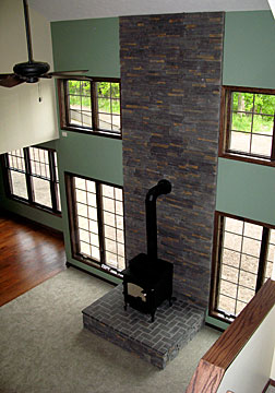 wood stove with 2-story brick wall